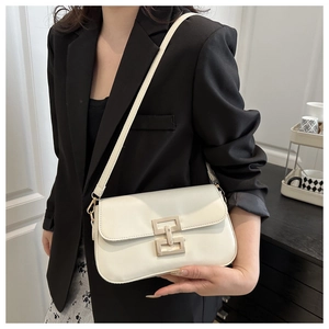 Close-up of a cream white leather crossbody bag with a gold geometric clasp buckle