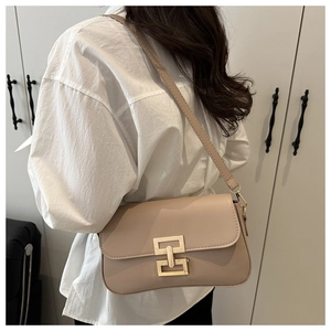 Detail of minimalist beige faux leather shoulder bag with golden geometric metal buckle