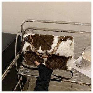 Détail du sac à bandoulière en peluche à motif vache avec chaîne marron et texture douce