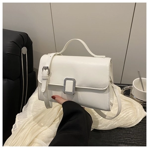 Detailed macro view of white PU leather square handbag with polished silver metal buckle