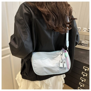 Détail du sac bandoulière bleu clair avec broderie et sangle réglable assortie