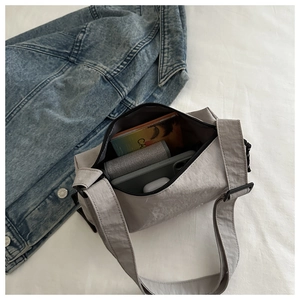 Spacious interior of light grey nylon crossbody bag showing daily storage capacity