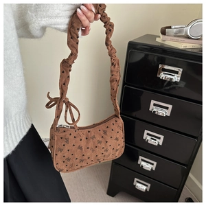 Detail of brown corduroy bag with heart bow pattern and pleated shoulder strap