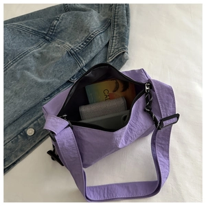 Internal view of purple nylon crossbody bag showing storage for phone and wallet