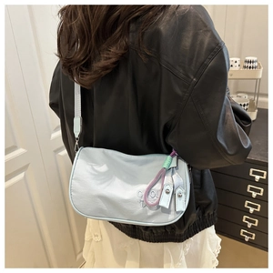 Vue arrière du sac à bandoulière en nylon bleu clair brillant porté par le mannequin