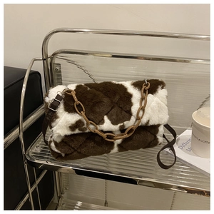 Détail du sac en peluche à motif vache avec chaîne en résine marron et texture douce