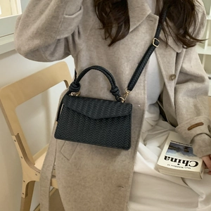 Women's black woven crossbody bag with golden hardware and adjustable strap