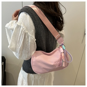 Détail du sac hobo en nylon rose avec broderie CHOU et breloque en corde tressée