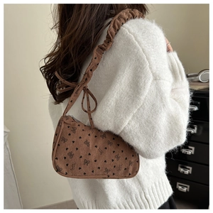 Brown corduroy shoulder bag featuring bow patterns and a pleated strap detail