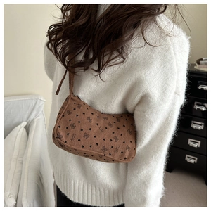 Detailed close-up of brown corduroy shoulder bag with heart and bow patterns
