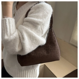 Detail of dark brown leopard embossed tote bag with suede texture and metal zipper closure