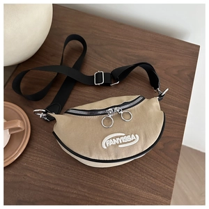 Détail du sac croissant en toile kaki avec anneaux argentés et broderie blanche