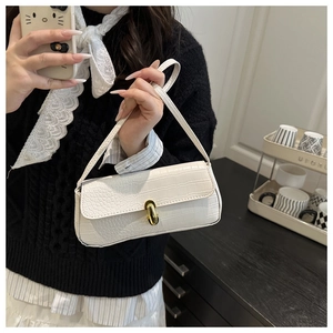 Detail of white crocodile embossed baguette bag with elegant golden metallic lock closure
