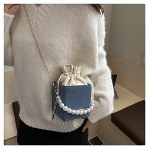 Dettaglio borsa a tracolla in pelle scamosciata blu con tracolla di perle e coulisse in pelle