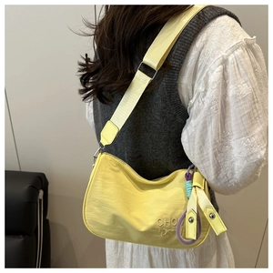 Détail du sac hobo en nylon jaune clair avec broderie personnalisée de lettres CHOU