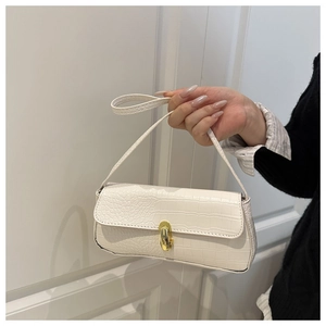 Close-up of white crocodile pattern baguette bag with a premium gold rotating metal clasp