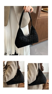 Close-up of black leopard embossed pattern on a hobo shoulder bag with zipper detail