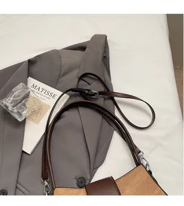 Detail of brown and khaki patchwork bag showing long smooth shoulder strap texture