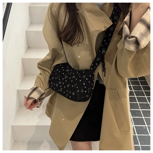 Crossbody bag with bow heart print shown on a model in a minimal indoor setting