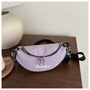 Vue détaillée du sac banane croissant violet clair sur une table avec décor de style de vie
