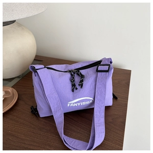 Detailed close-up of lavender nylon crossbody bag with adjustable strap and logo