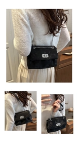 Detail of black crossbody bag with silver diamond buckle and metallic textured finish