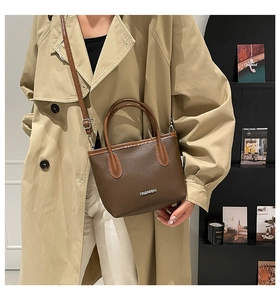 Vue détaillée du sac seau marron en cuir grainé avec logo métallique Fashion et sangle
