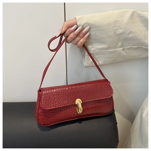 Close-up of red crocodile-embossed baguette bag with a polished gold metal buckle