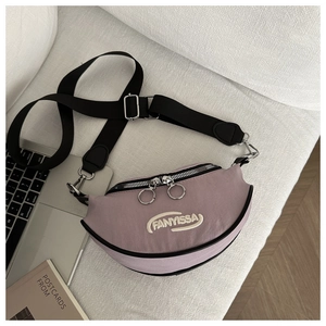Détail du sac bandoulière lavande en forme de croissant avec logo brodé blanc FANYISSA