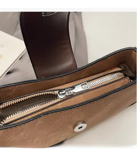 Detailed macro view of silver metal zipper and magnetic buckle on brown textured handbag