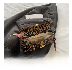 Spacious interior of leopard print underarm bag showing phone, wallet and cosmetics