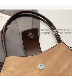 Detail of a brown fabric baguette bag featuring a strong magnetic snap closure