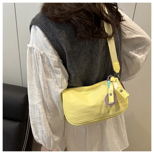 Détail du sac à bandoulière jaune clair avec broderie et sangle tissée large