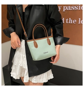 Gros plan d'un sac seau vert menthe avec lanières marron et logo Fashion