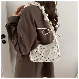 Detail of pleated cloud strap and brown heart print on corduroy shoulder bag
