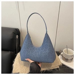 Detail of blue leopard embossed texture on a hobo shoulder bag with matte leather finish