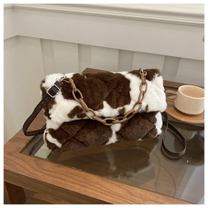 Détail du sac bandoulière en peluche à motif vache avec chaîne marron et matelassage