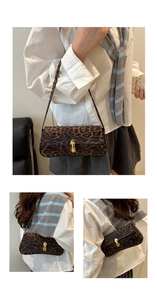 Macro detail of leopard print baguette bag with gold metal buckle and textured finish