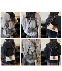 Model wearing a vintage baguette bag in marble grey and beige on a shoulder strap