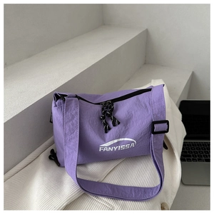 Detail of purple nylon crossbody bag with white FANYISSA text on minimalist suit background