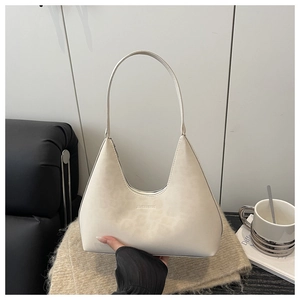 Close-up of minimalist cream white faux leather hobo bag with embossed logo detail
