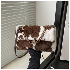 Détail du sac en peluche à motif vache avec texture matelassée et chaîne en acrylique