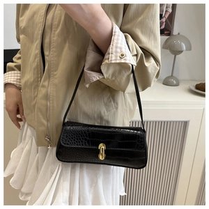 Close-up of black crocodile pattern baguette bag with a golden U-shaped metal lock
