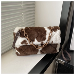 Vue détaillée du sac bandoulière en peluche à motif vache avec surpiqûres et chaîne