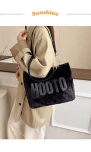 Detail of black faux fur tote bag with leather HOOTO lettering and silver chain strap