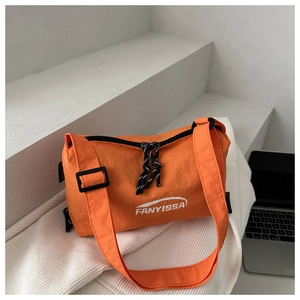 Detail of orange nylon crossbody bag with white logo and adjustable shoulder strap