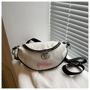 Détail du sac banane croissant blanc cassé avec fermetures noires et broderie FANYISSA