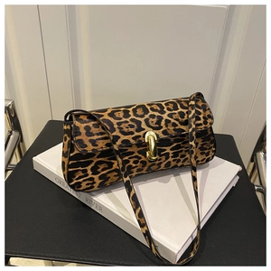 Close-up of leopard print baguette bag with golden capsule metal clasp on book