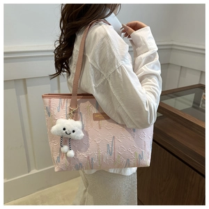 Dettaglio della borsa tote a righe rosa in tessuto jacquard e ciondolo a nuvola soffice