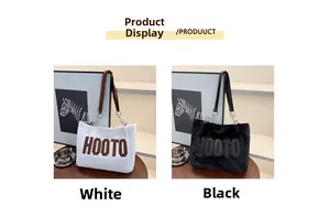 Detail view of plush shoulder bags in white and black with embroidered HOOTO lettering